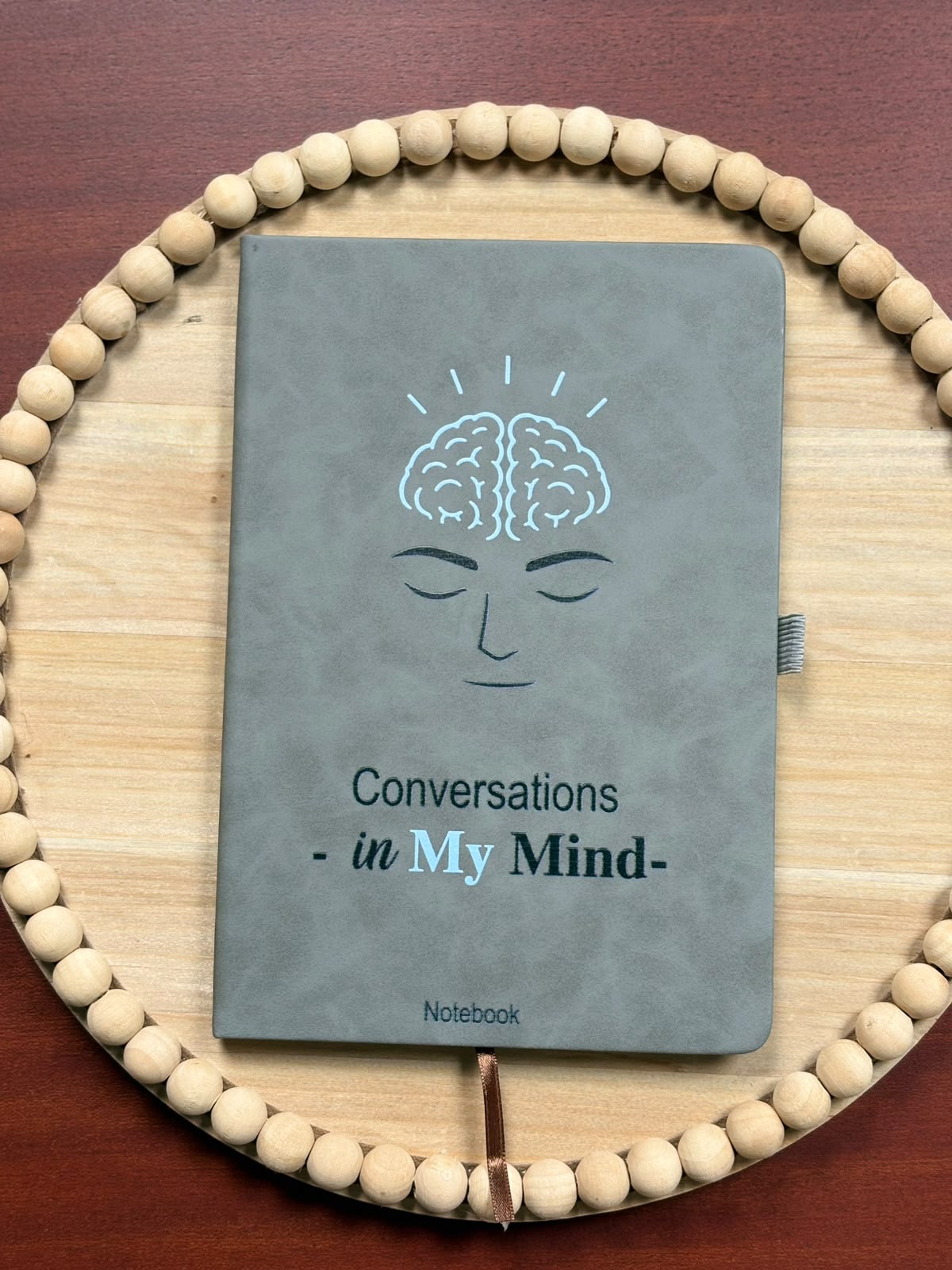 Grey Conversations in My Mind notebook on a wooden beaded tray
