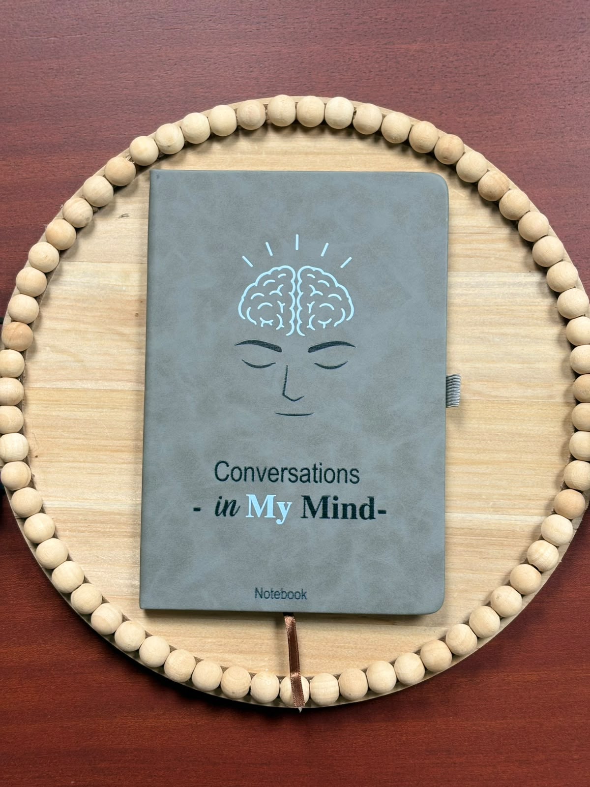 Grey Conversations in My Mind notebook with an illustrated face and brain on the cover
